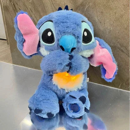 Blaues Plüschtier mit großen Ohren, leuchtendem Bauch und niedlichem Gesicht auf Tisch